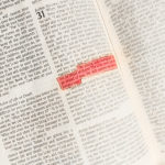 A well used Bible with Deuteronomy 31:6 highlighted in pink.